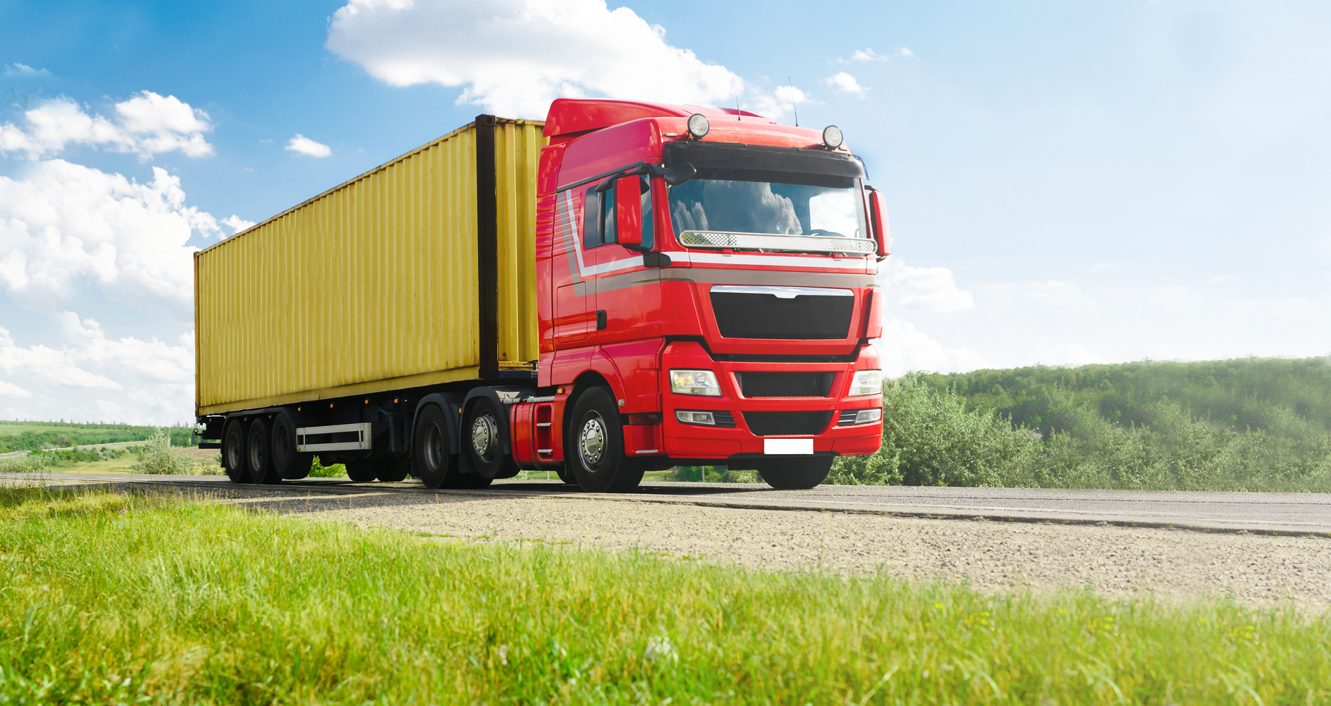 European red Truck  with container on highway and blue sky with  clouds. Cargo transportation concept.